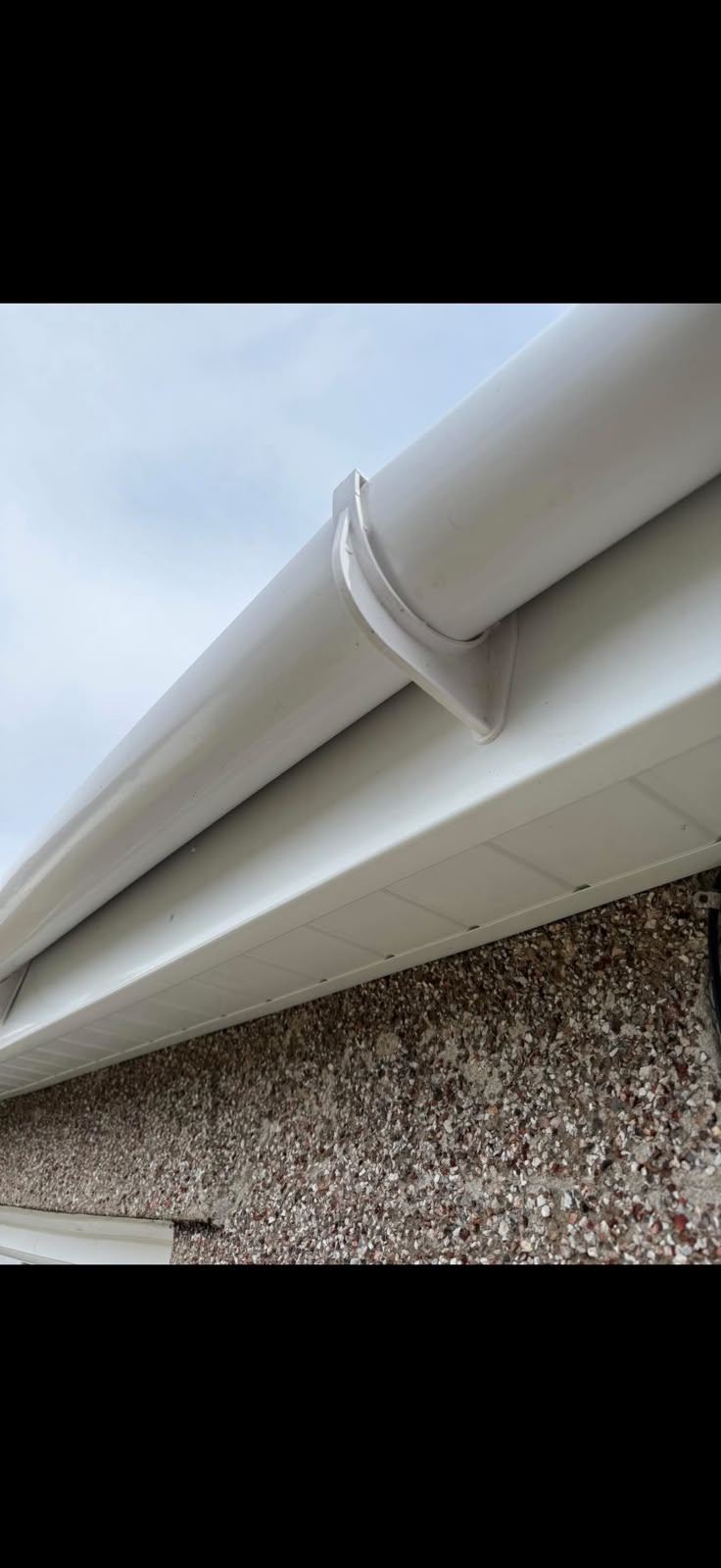 White guttering along a roofline from TJS Roofing Solutions
